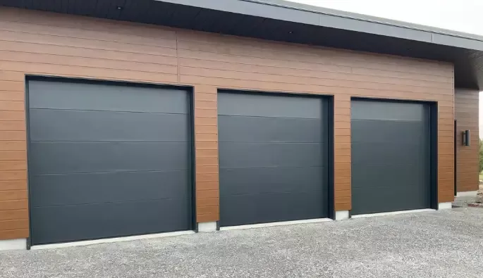 Three adjacent garage doors with stylish black panels, contributing to a uniform and modern exterior appearance.